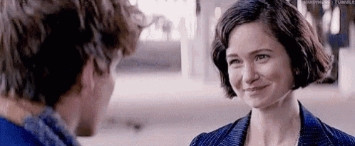 a man and a woman are smiling at each other while looking at each other .