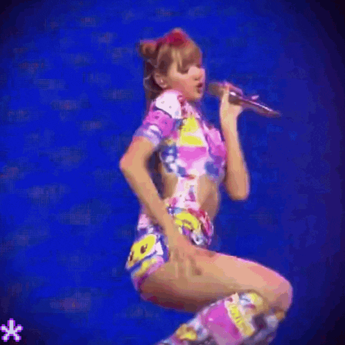 a woman is kneeling down on a stage wearing a hello kitty shirt .