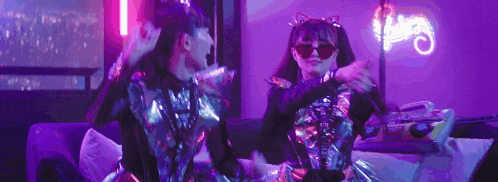 a man and a woman are dancing in a room with neon lights .