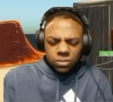 a man wearing headphones and a hoodie is making a face .