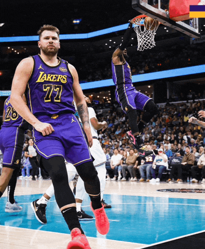 basketball player wearing a purple lakers jersey jumping in the air