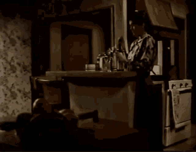 a woman is standing in a kitchen with a towel on the oven