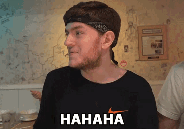 a man wearing a bandana and a black nike shirt says hahaha