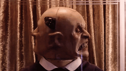 a statue of a bald man with a mask on his face
