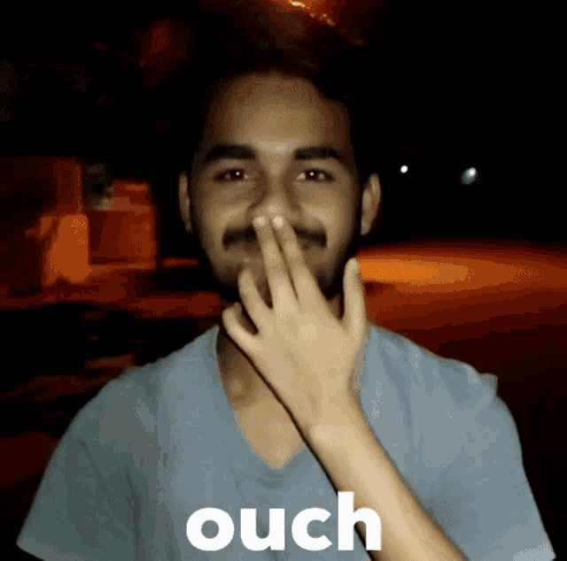 a man with a beard is being kissed by a woman with the word ouch written on the bottom