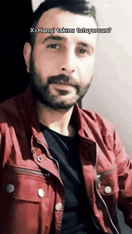 a man with a beard is wearing a red jacket and a black shirt with the caption x = hangi takimi tutuyorsun