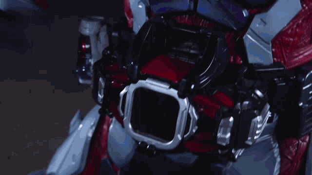 a close up of a robot 's chest with a purple and red light on it
