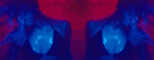 a woman in a bikini is covering her eyes with her hands in a blue light .