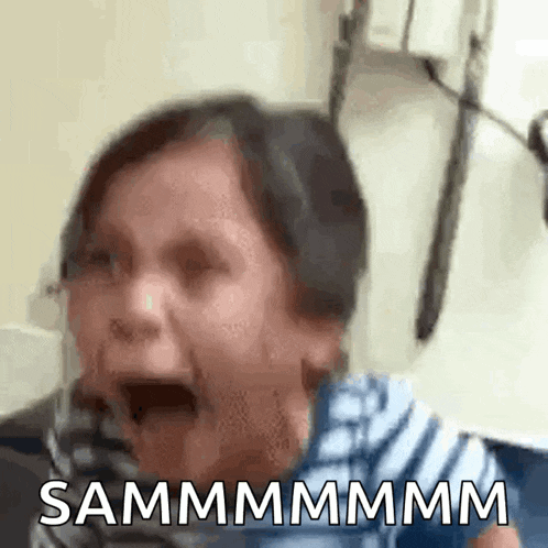 a little girl is crying with her mouth open and the words sammmmmm written on the bottom of her face .