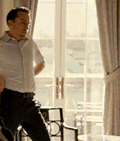 a man in a white shirt is standing in front of a window