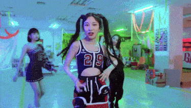 a woman in a number 29 tank top is dancing in a room