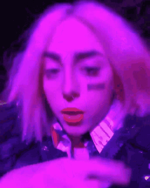 a woman with purple hair is pointing at something