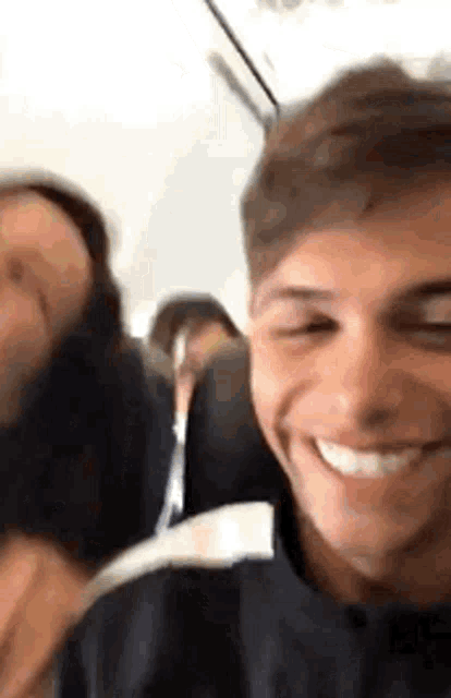 a man and a woman are sitting on an airplane and smiling .