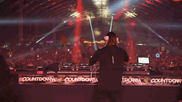a dj stands behind a counter that says countdown on it