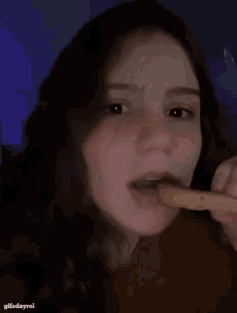 a close up of a woman eating a french fry