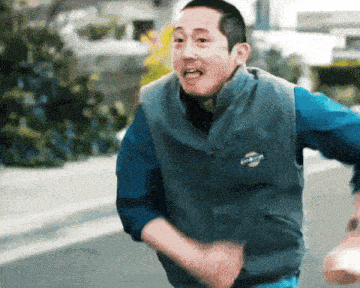 a man wearing a blue shirt and a grey vest that says ' columbia ' on it