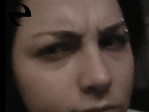 a close up of a woman 's face with a crescent moon in the background