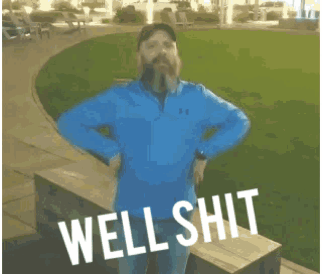 a man in a blue under armour jacket is standing in a park with the words well shit written below him