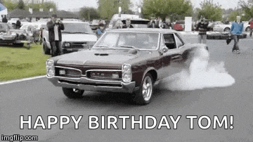 a car is driving down a road with smoke coming out of its tires .
