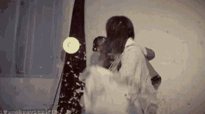 a man and a woman are standing next to each other in a room with a lamp .