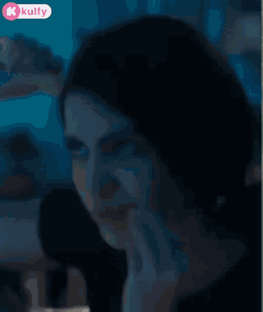 a close up of a woman 's face with a hand on her mouth .