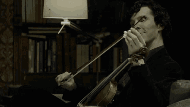 a man is smiling while playing a violin in front of a lamp