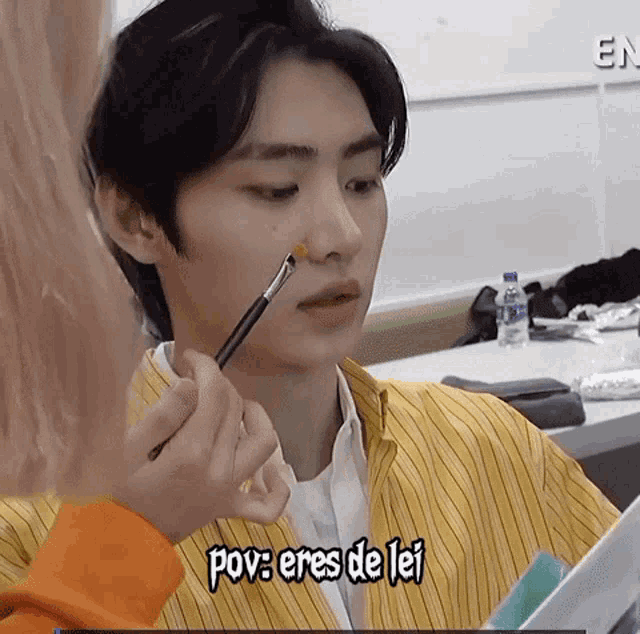 a person is applying makeup to a man 's face and the caption says pov : eres de lei
