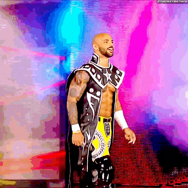 a man in a wrestling outfit is standing in front of a screen that says thenextbig thing