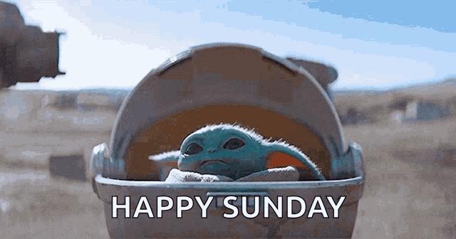 a baby yoda is sitting in a stroller with the words `` happy sunday '' written on the bottom .