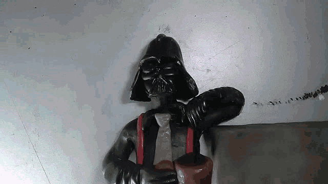 a statue of darth vader is holding a bottle