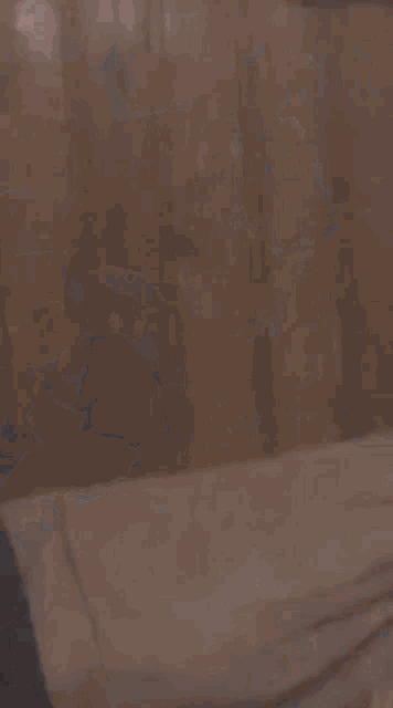 a man with a beard is sitting at a table in a dark room with other people .