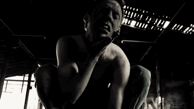 a man without a shirt is making a face with his hands on his chest