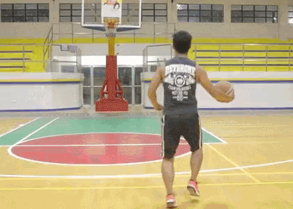 a man is holding a basketball on a court .