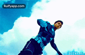 a man in a blue superhero suit is flying through the air .