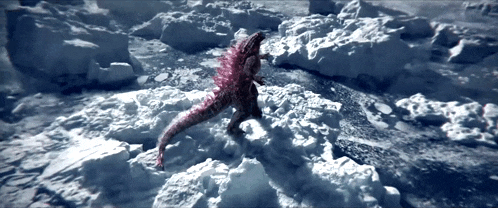 a dinosaur is walking through a snowy area with a few rocks in the background