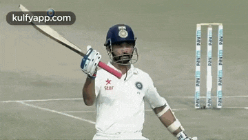 a cricket player with a star on his shirt is holding a bat