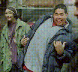a man in a blue jacket is standing next to a woman in a green coat