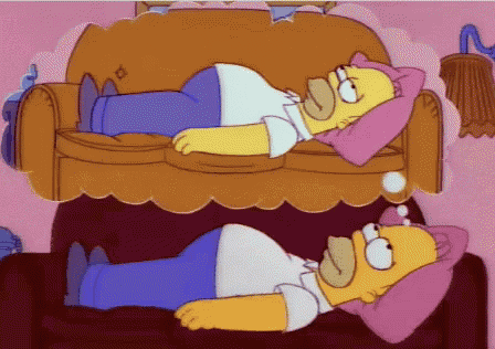 homer simpson laying on a couch with a pink pillow