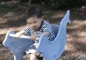 a little boy is sitting on a blue rocking horse .