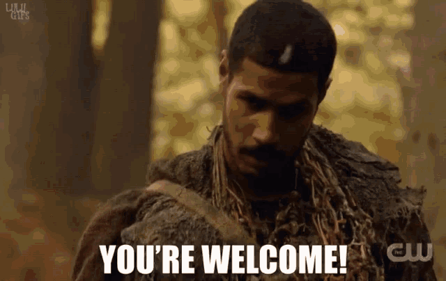 a man says you 're welcome in front of a cw logo