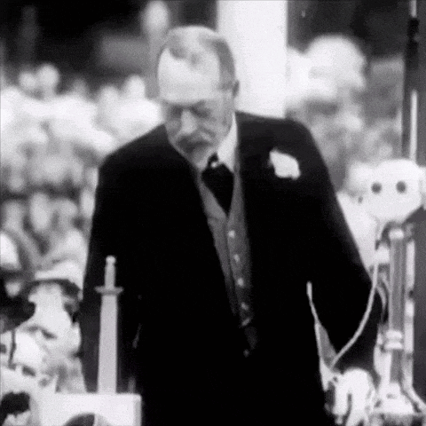 a man in a suit is standing in front of a crowd