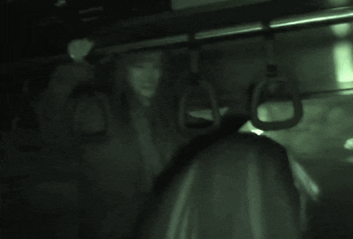 a person is hanging from a railing on a train