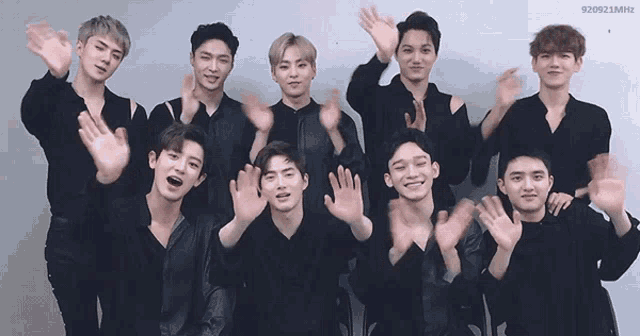 a group of young men are posing for a picture with their hands up in the air