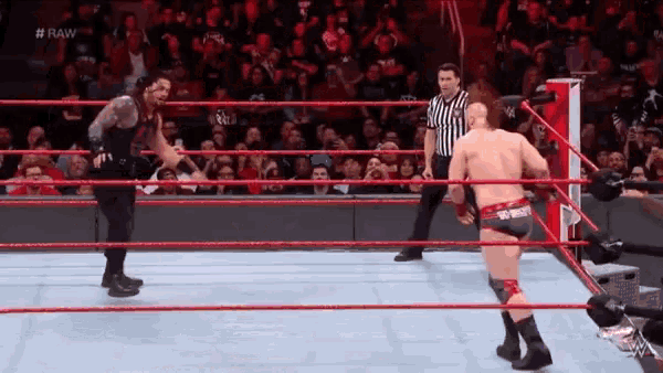 a wrestling match is taking place in a ring with a referee .