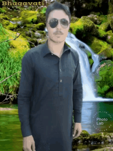 a man wearing sunglasses is standing in front of a waterfall with the name bhagavati on the bottom