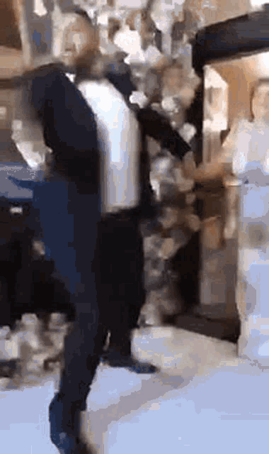 a man in a tuxedo is standing in front of a crowd of people .