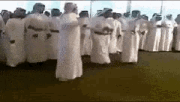 a group of people in white robes are standing in a line