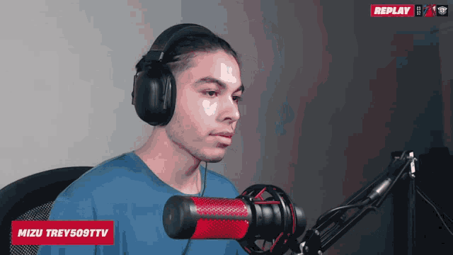 a man wearing headphones stands in front of a microphone that says mizu trev509tv on it