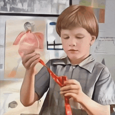 a young boy is tying a red tie in front of a painting of a man
