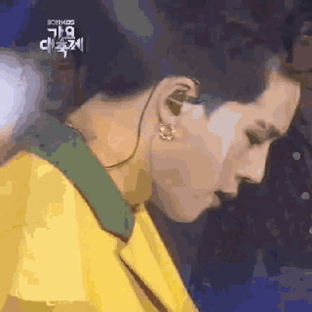 a close up of a person 's face with a yellow jacket on
